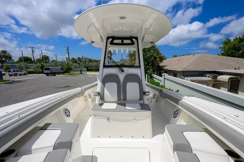 Slide: The Image of 2023 Regulator 28 boat interior with seating, under a clear blue sky. - 22