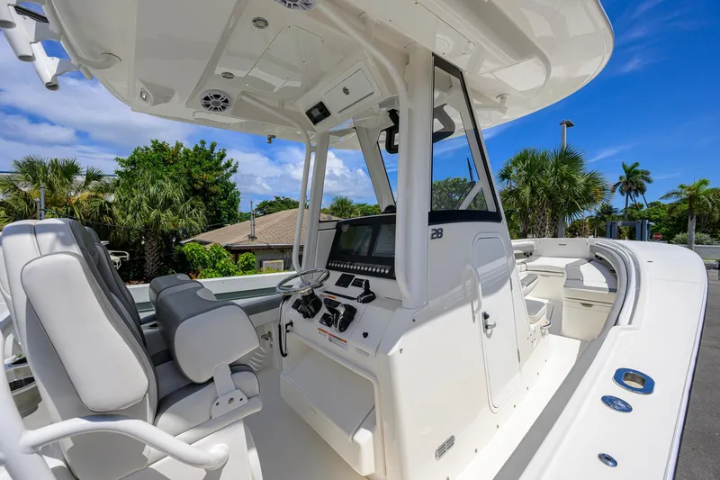 Slide: The Image of 2023 Regulator 28 boat interior with helm, seats, and clear blue sky background. - 25