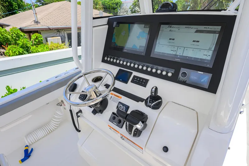 Slide: The Image of 2023 Regulator 28 boat dashboard with dual screens and steering wheel. - 27