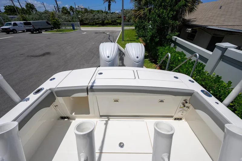 Slide: The Image of 2023 Regulator 28 boat stern view with dual engines, docked in a sunny marina. - 31