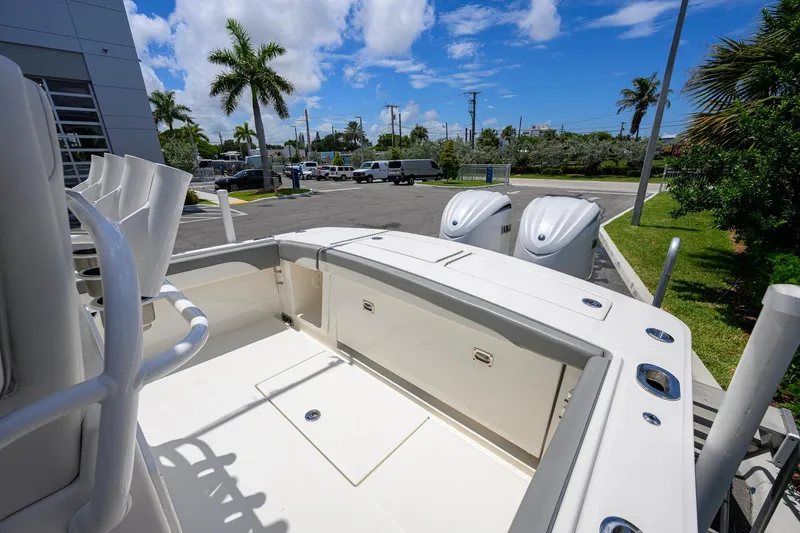 Slide: The Image of 2023 Regulator 28 boat with dual engines, parked near palm trees under a blue sky. - 32