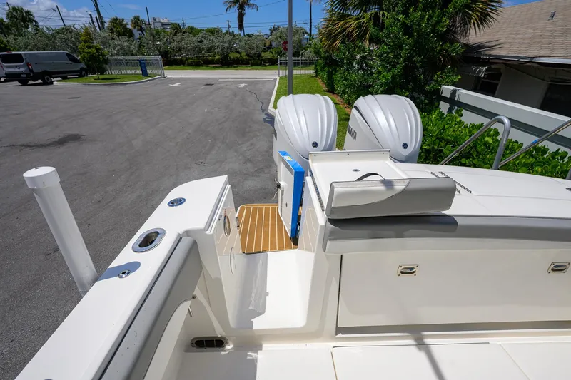 Slide: The Image of 2023 Regulator 28 boat with dual Yamaha engines, docked in a sunny marina. - 34