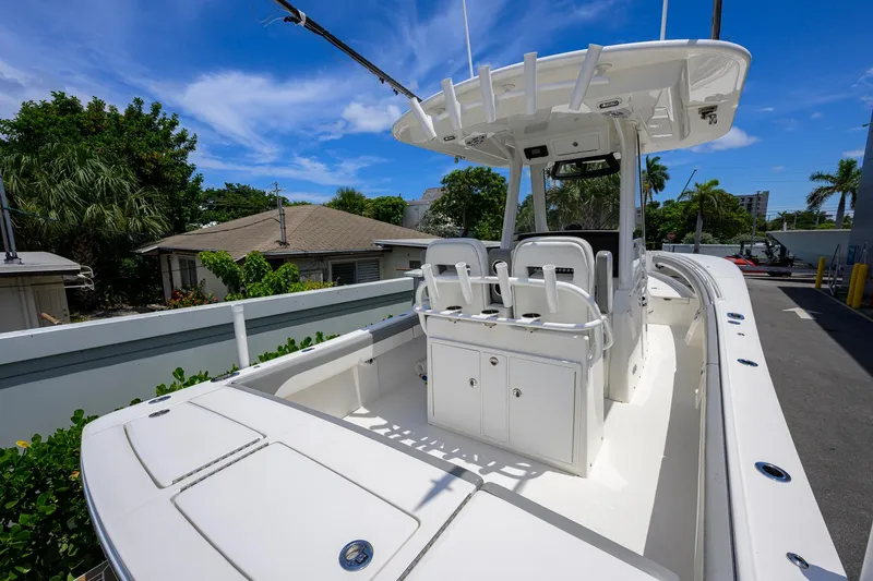 Slide: The Image of 2023 Regulator 28 boat with center console and seating, parked outdoors under blue sky. - 36