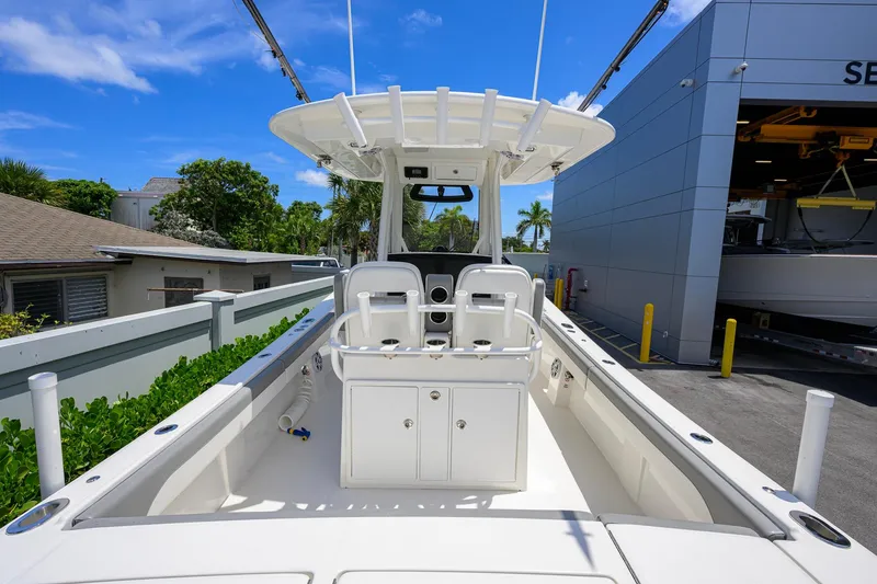 Slide: The Image of 2023 Regulator 28 boat interior with seating and storage, docked near service building. - 37