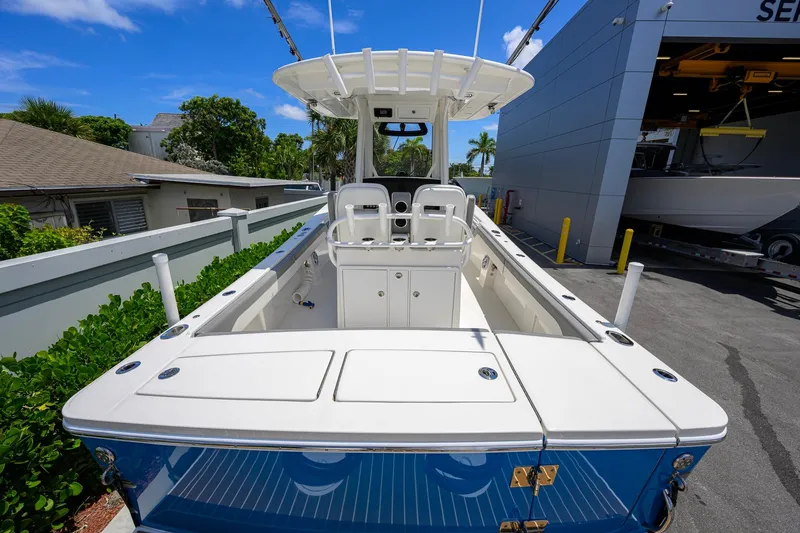 Slide: The Image of 2023 Regulator 28 boat with spacious deck, docked near service area under clear blue sky. - 41