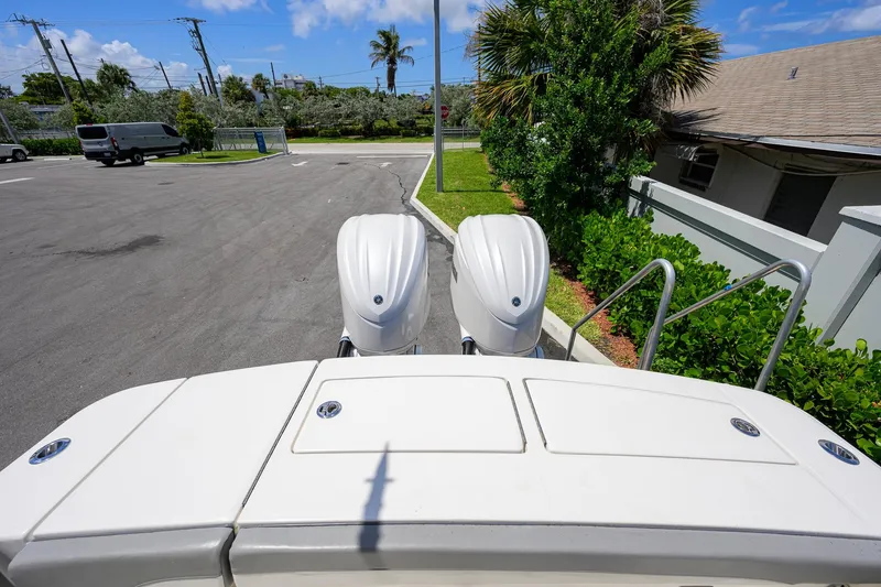 Slide: The Image of 2023 Regulator 28 boat with dual engines, parked near greenery and a building. - 42