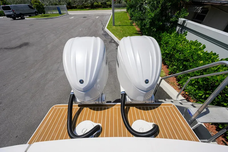 Slide: The Image of 2023 Regulator 28 boat with dual outboard engines on a wooden deck. - 43