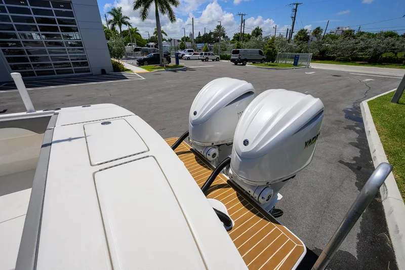 Slide: The Image of 2023 Regulator 28 boat with twin outboard engines in a sunny parking lot. - 48