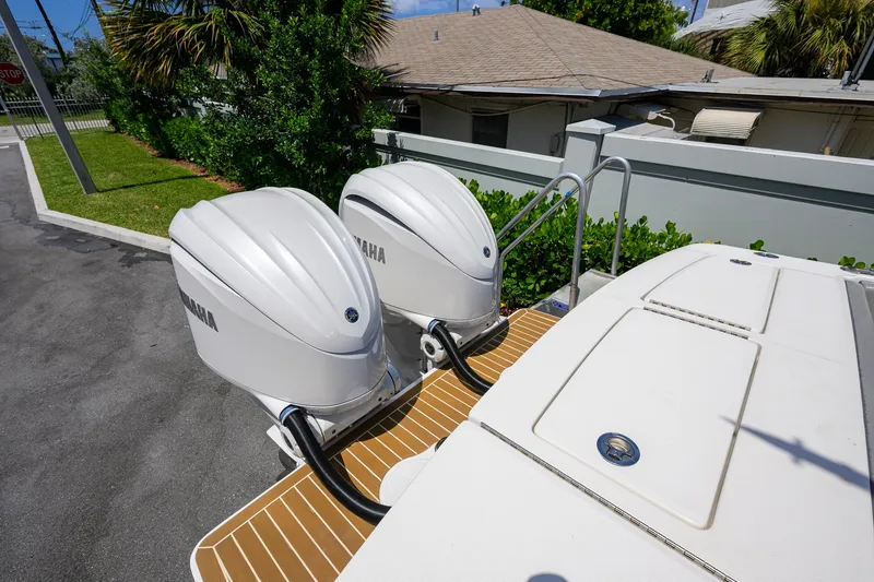 Slide: The Image of 2023 Regulator 28 boat with dual Yamaha outboard engines, docked outdoors. - 49