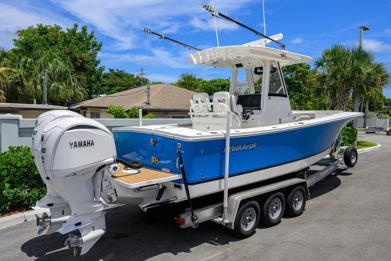 Slide: The Image of 2023 Regulator 28 boat with Yamaha engines on a trailer, parked outdoors. - 5