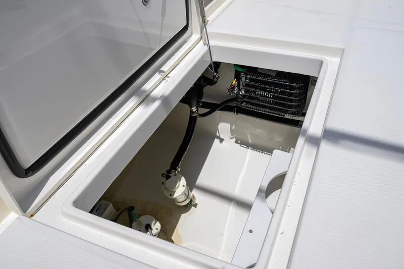 Slide: The Image of Open storage compartment on 2023 Regulator 28 boat, showcasing internal components and wiring. - 54