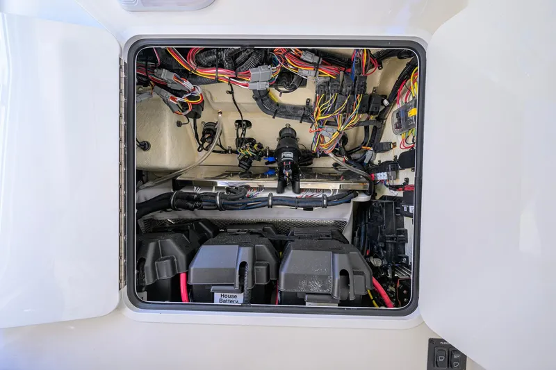 Slide: The Image of 2023 Regulator 28 boat electrical compartment with wiring and battery setup. - 55