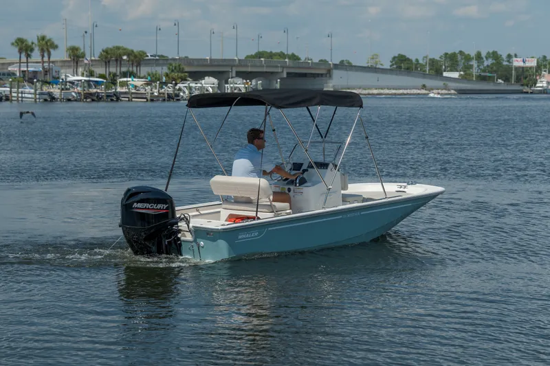 Slide: The Image of A 2027 Boston Whaler 150 Montauk on calm waters, featuring a Mercury outboard motor. - 4