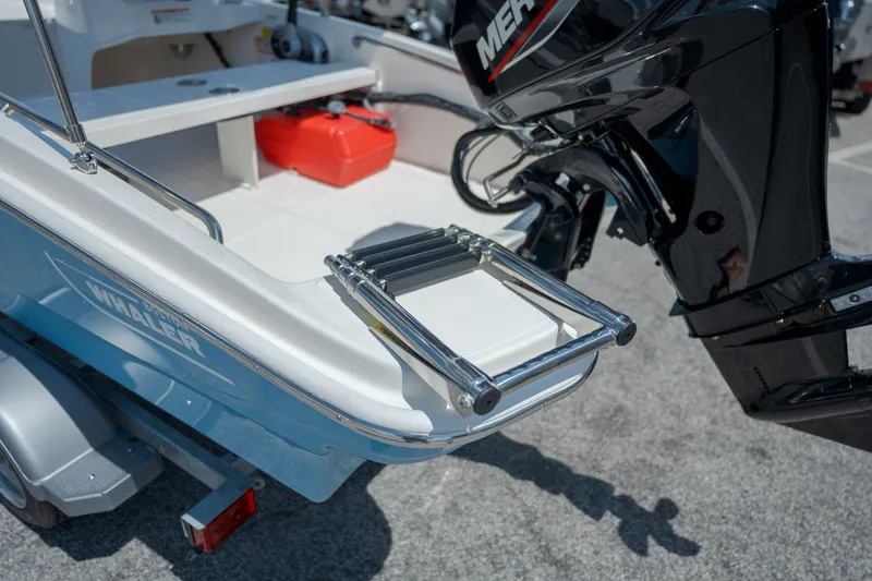 Slide: The Image of The 2027 Boston Whaler 130 Super Sport features a swim ladder and an outboard motor. - 17