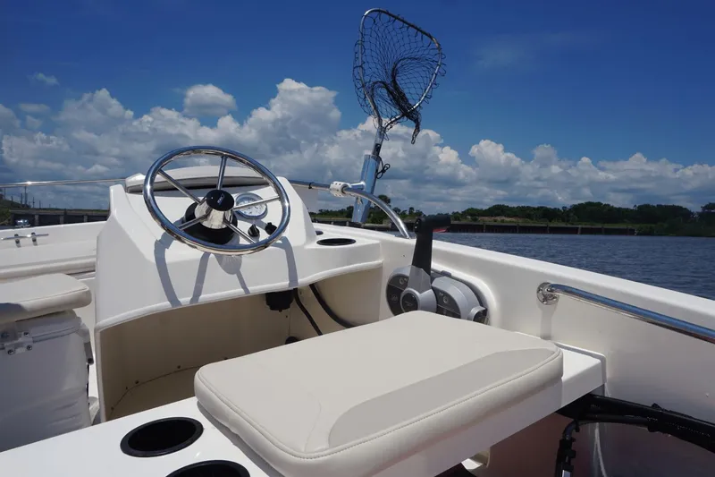 Slide: The Image of The image shows the cockpit of a 2027 Boston Whaler 130 Super Sport with a steering wheel and net. - 42