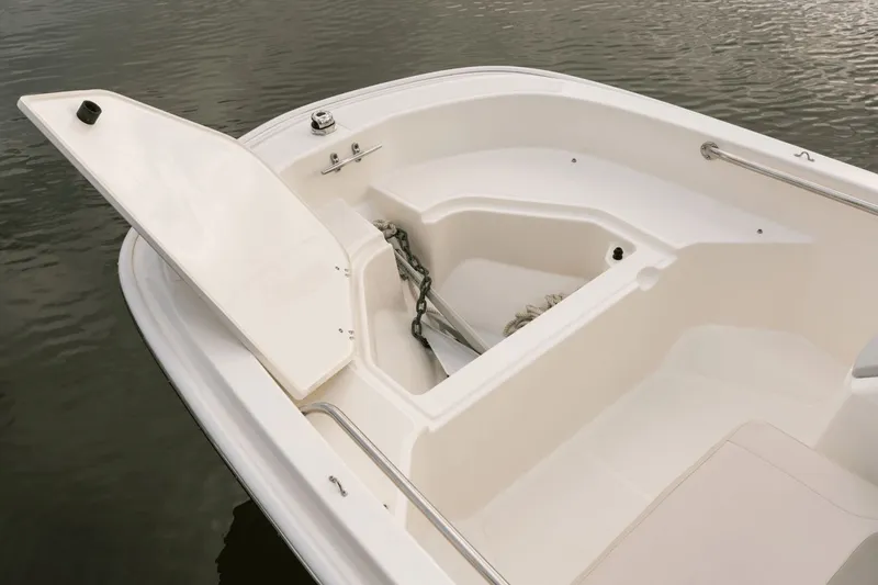 Slide: The Image of The image shows the bow of a 2027 Boston Whaler 130 Super Sport with open storage. - 37