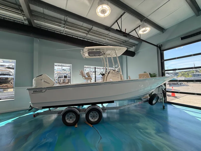 Slide: The Image of A 2027 Boston Whaler 210 Montauk on a trailer in a showroom setting. - 0