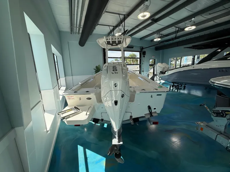 Slide: The Image of A 2027 Boston Whaler 210 Montauk in a modern showroom with a blue floor. - 7