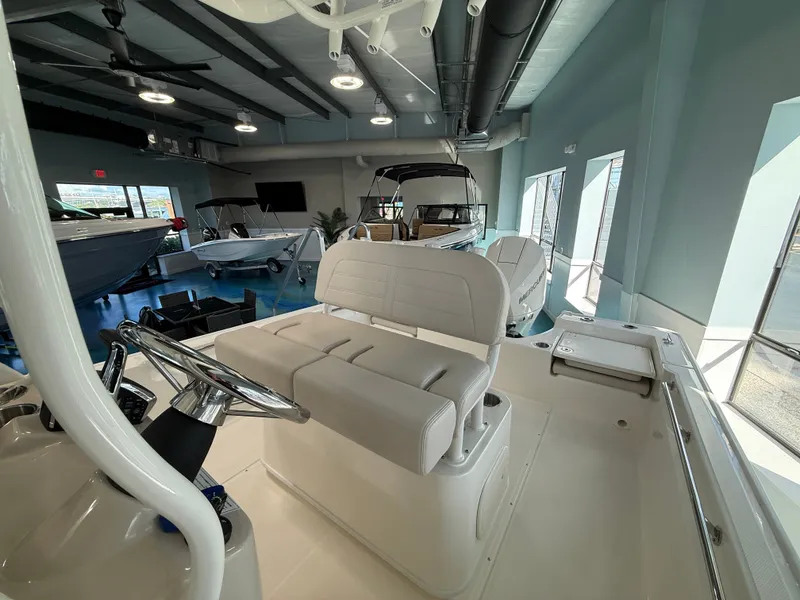 Slide: The Image of Interior of a Boston Whaler 210 Montauk with beige seating and steering console. - 13