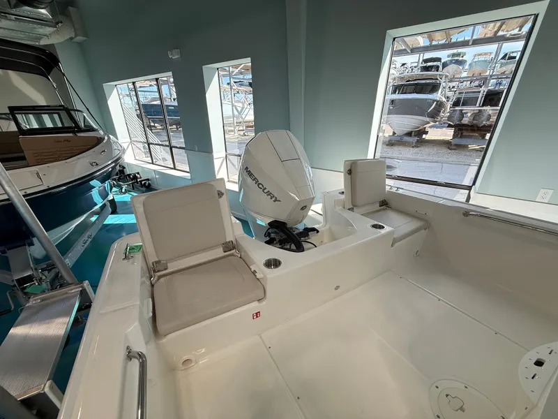 Slide: The Image of The image shows the cockpit of a 2027 Boston Whaler 210 Montauk with a Mercury engine. - 21
