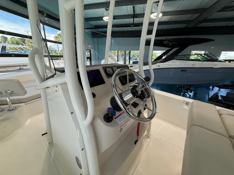 Slide: The Image of The image shows the helm of a 2027 Boston Whaler 210 Montauk in a showroom setting. - 14