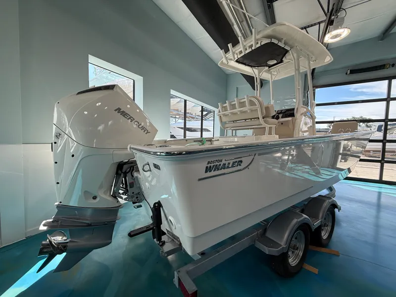 Slide: The Image of A 2027 Boston Whaler 210 Montauk on a trailer in a showroom. - 1