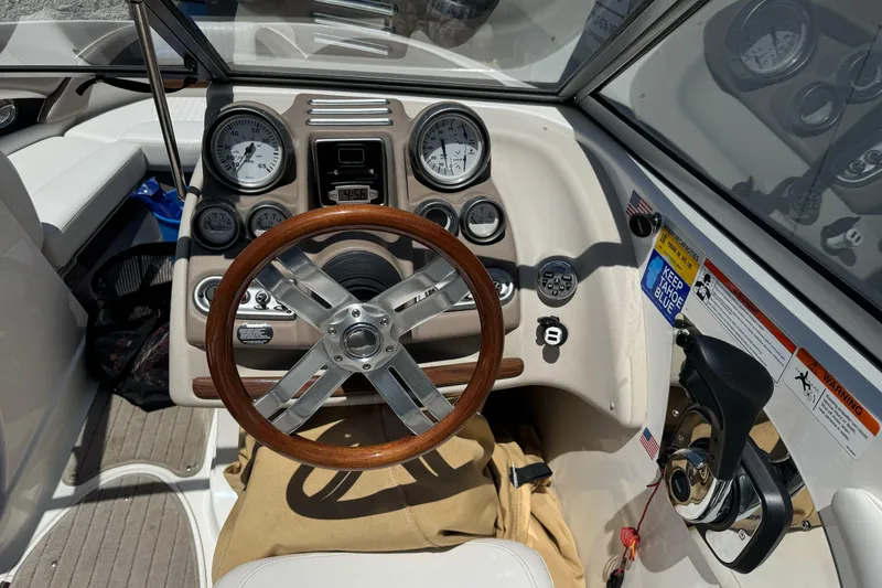 Slide: The Image of 2009 Glastron GLS 215 boat dashboard with wooden steering wheel and gauges. - 15