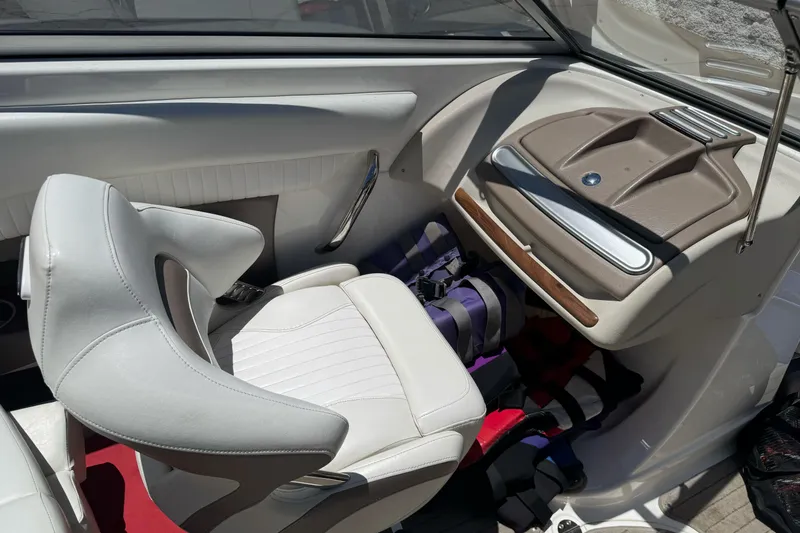 Slide: The Image of 2009 Glastron GLS 215 boat interior with white seating and dashboard details. - 16