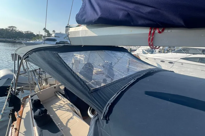 Slide: The Image of 1994 Island Packet 44 cutter sailboat with blue canvas cover at marina. - 16
