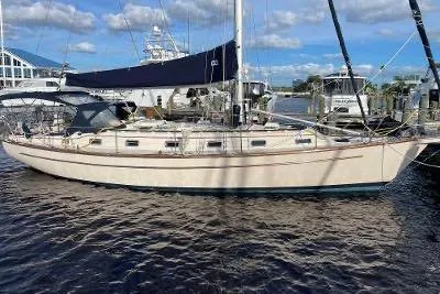 Slide: The Image of 1994 Island Packet 44 cutter sailboat docked at marina under blue sky. - 2