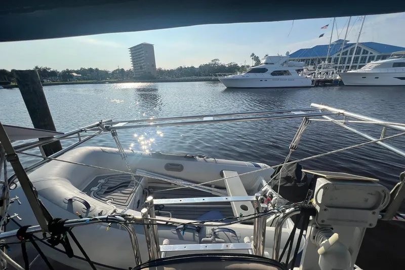 Slide: The Image of 1994 Island Packet 44 cutter sailboat docked with inflatable dinghy, marina view. - 43