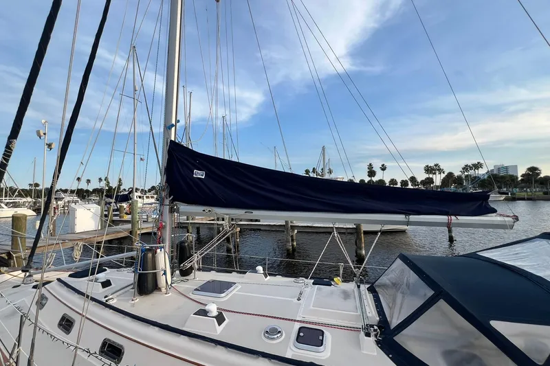 Slide: The Image of 1994 Island Packet 44 cutter sailboat docked at marina under clear sky. - 5