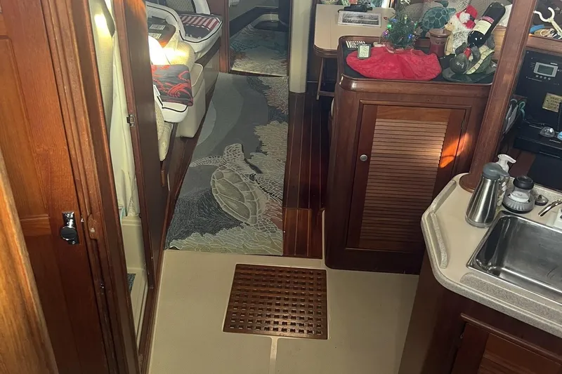 Slide: The Image of Interior of 1994 Island Packet 44 cutter with wood finishes and turtle-themed rug. - 60