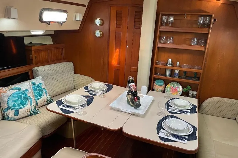 Slide: The Image of Cozy dining area inside 1994 Island Packet 44 cutter yacht, featuring elegant table setting. - 68