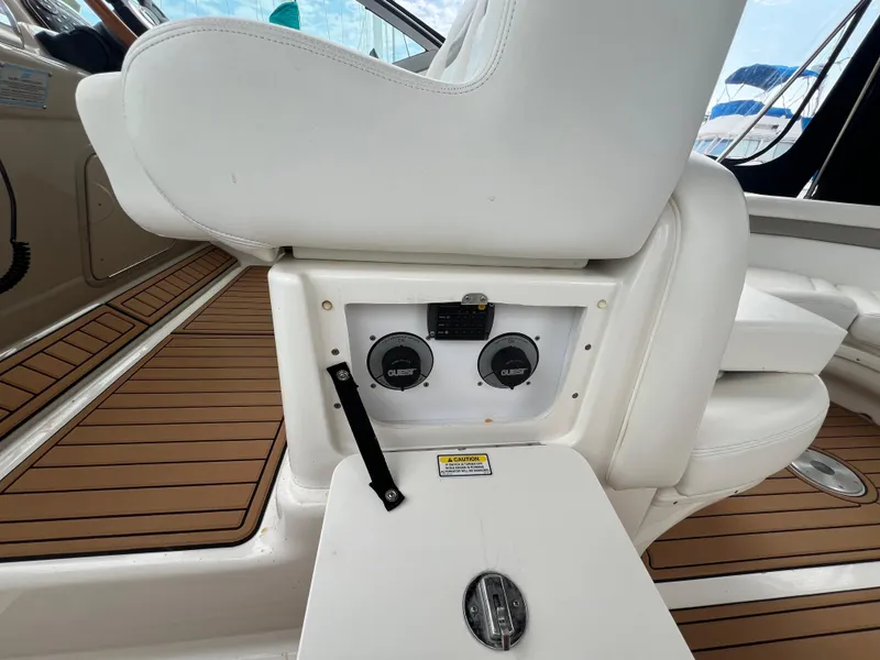 Slide: The Image of 2003 Sea Ray 320 Sundancer cockpit with white seating and wood-patterned flooring. - 25