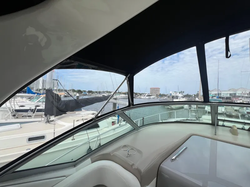 Slide: The Image of 2003 Sea Ray 320 Sundancer interior view at marina, showcasing helm and surrounding boats. - 27