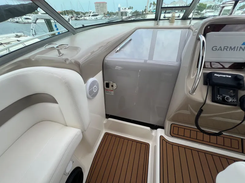 Slide: The Image of 2003 Sea Ray 320 Sundancer cockpit with Garmin navigation, wood flooring, and comfortable seating. - 29
