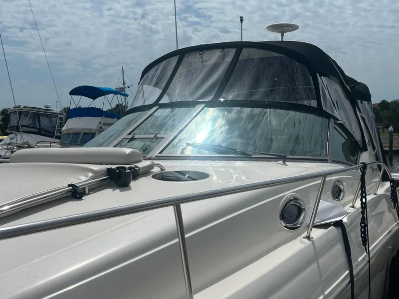 Slide: The Image of 2003 Sea Ray 320 Sundancer boat with sleek design and clear canopy under cloudy sky. - 7