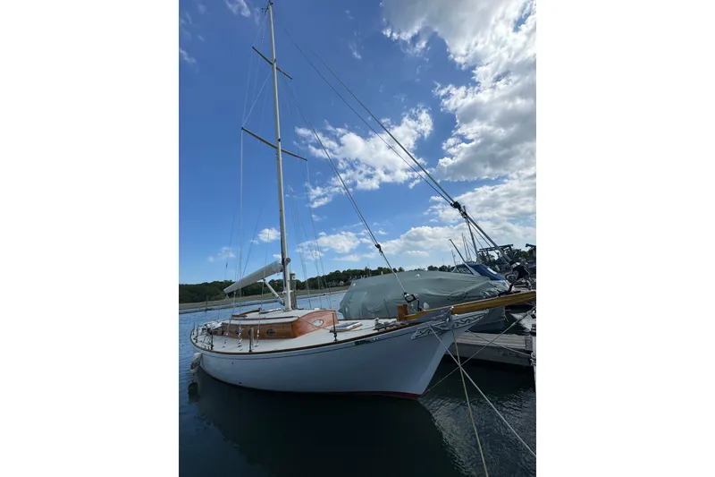 The Image of 1979 O.Lie-Neilsen 44 Cutter Rigged sailboat docked under blue sky. - 0