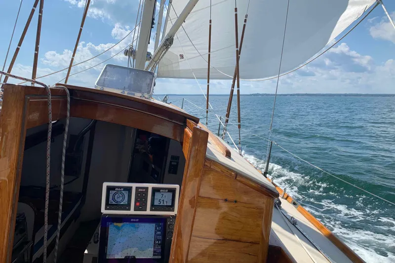 Slide: The Image of Sailing on a 1979 Nielsen 44 Cutter Rigged yacht, navigating open waters under clear skies. - 5