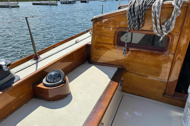 Slide: The Image of 1979 Nielsen 44 Cutter Rigged sailboat deck with compass and ropes, docked on calm water. - 8
