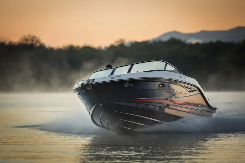 The Image of 2016 Sea Ray SLX 250 boat cruising at sunset on the water. - 2