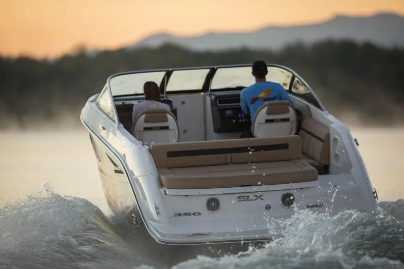 Slide: The Image of 2016 Sea Ray SLX 250 boat cruising on water at sunset. - 23