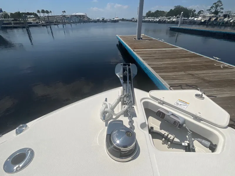 Slide: The Image of The image shows the bow of a 2027 Boston Whaler 250 Outrage docked at a calm marina. - 18