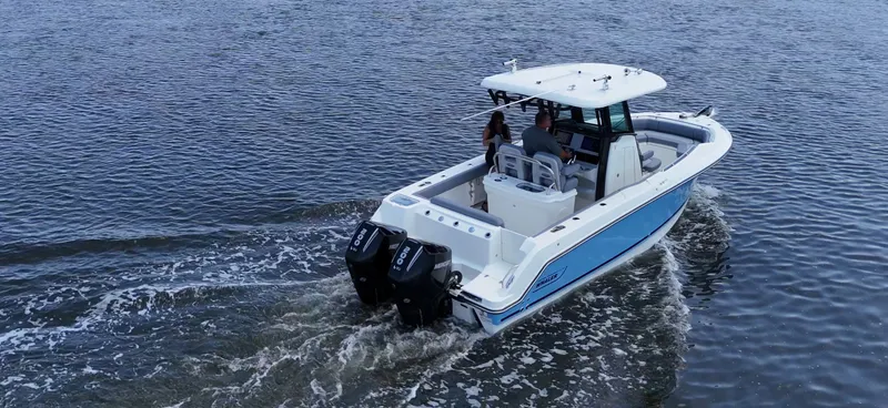 Slide: The Image of A 2027 Boston Whaler 250 Outrage cruising on calm water. Two people are seated in the cockpit. - 3