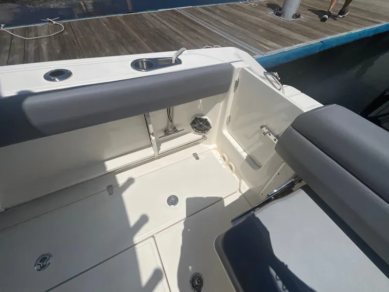 Slide: The Image of The image shows the cockpit of a 2027 Boston Whaler 250 Outrage. It features cushioned seating and stainless steel fittings. - 8