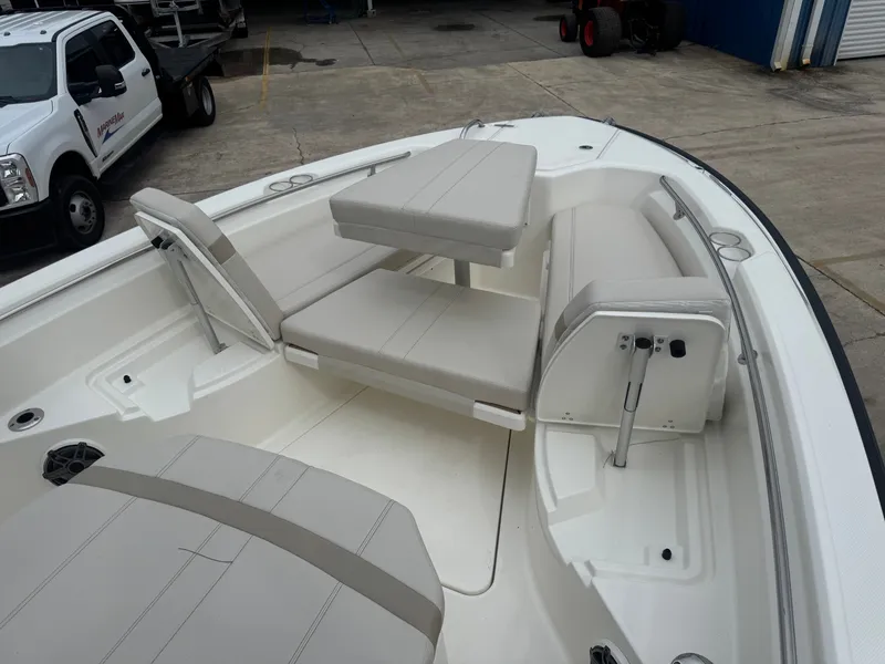 Slide: The Image of The image shows the deck of a Boston Whaler 280 Dauntless with beige cushioned seats and a table. - 15