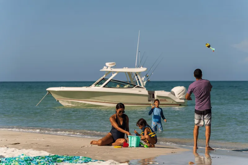 Slide: The Image of Family enjoying the beach with a Boston Whaler 280 Vantage in the background. - 19