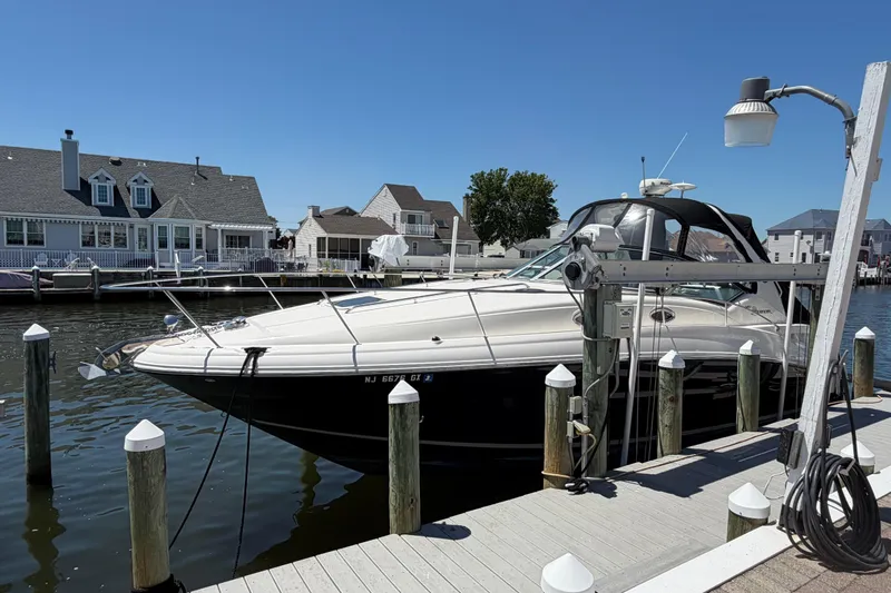 Slide: The Image of 2006 Sea Ray Sundancer 320 docked at a marina, surrounded by waterfront homes. - 1
