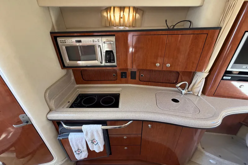 Slide: The Image of 2006 Sea Ray Sundancer 320 yacht kitchen with microwave, stove, and sink. - 10